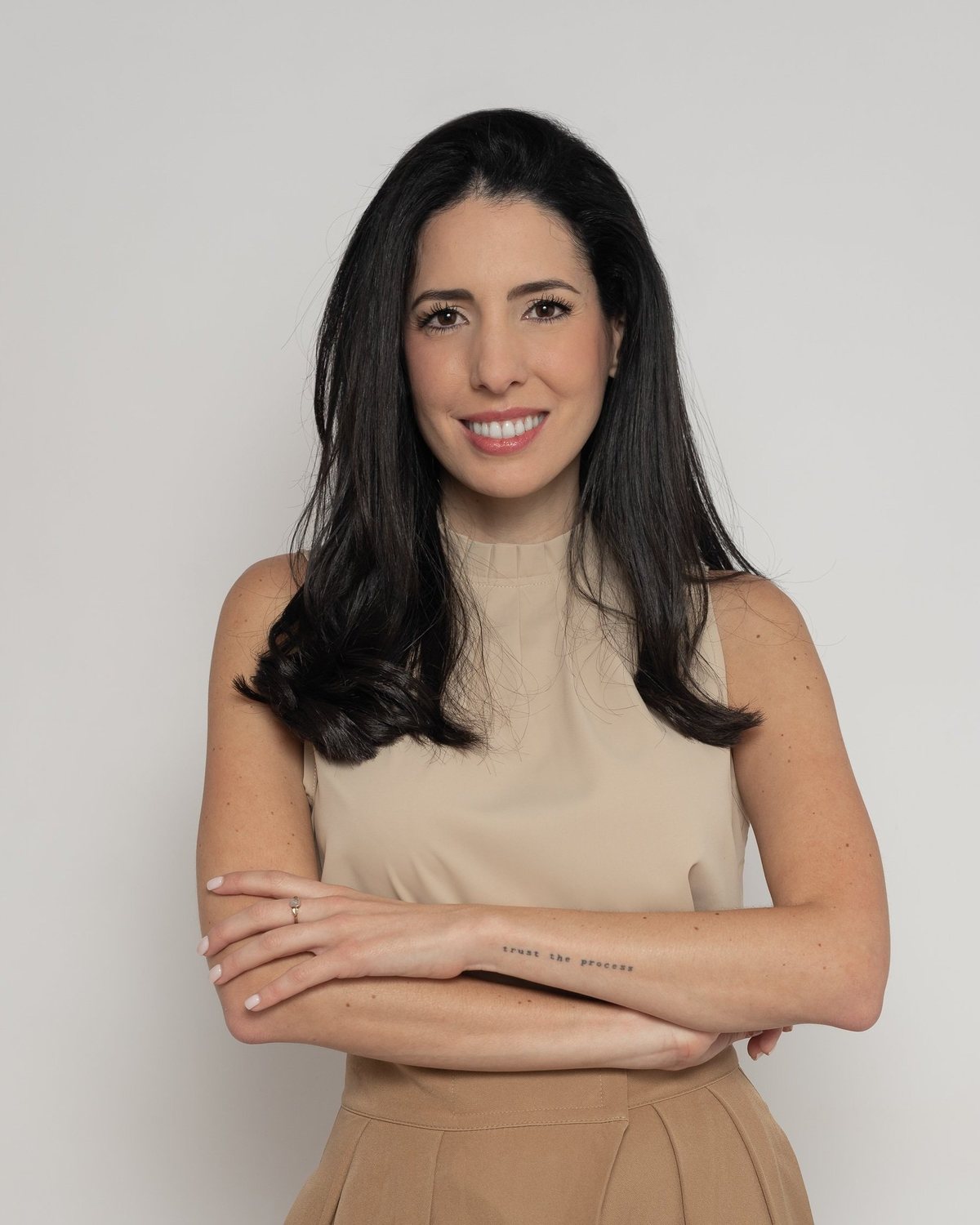 Caro Rodriguez, holistic therapist, smiling in a beige top
