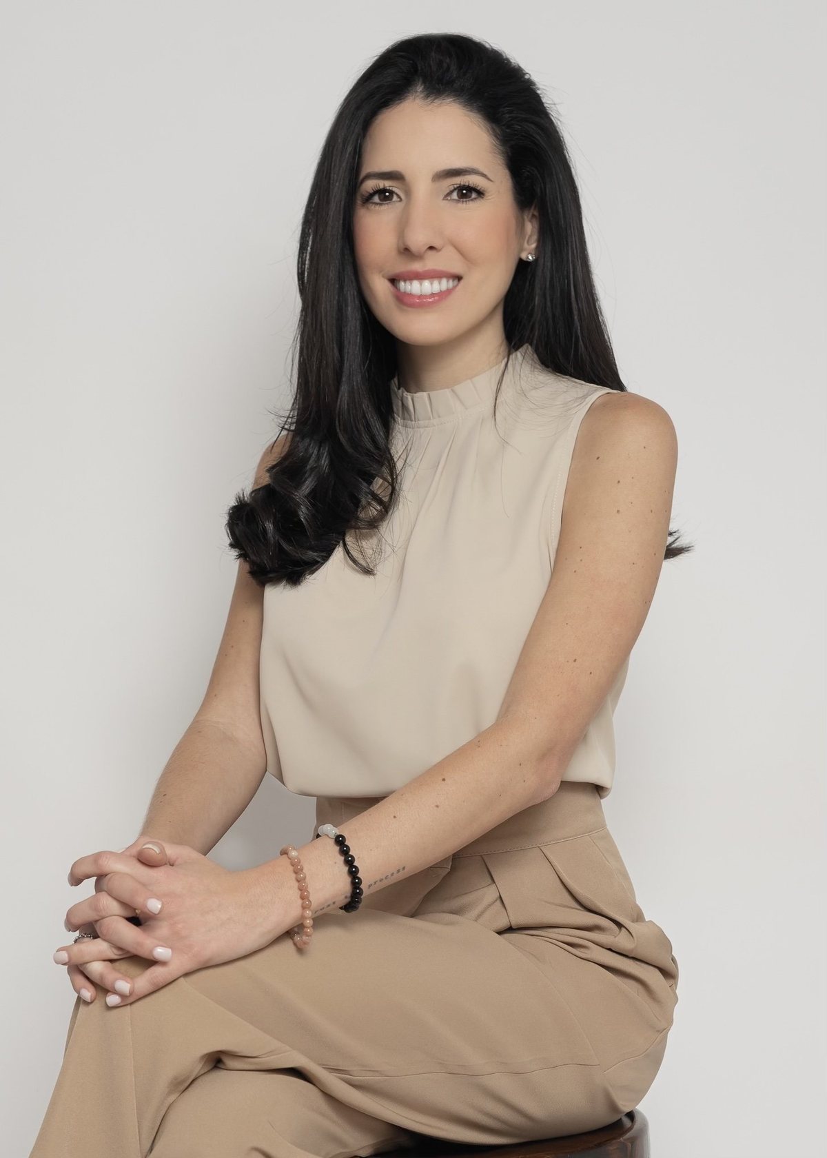 Caro Rodriguez seated, hands clasped