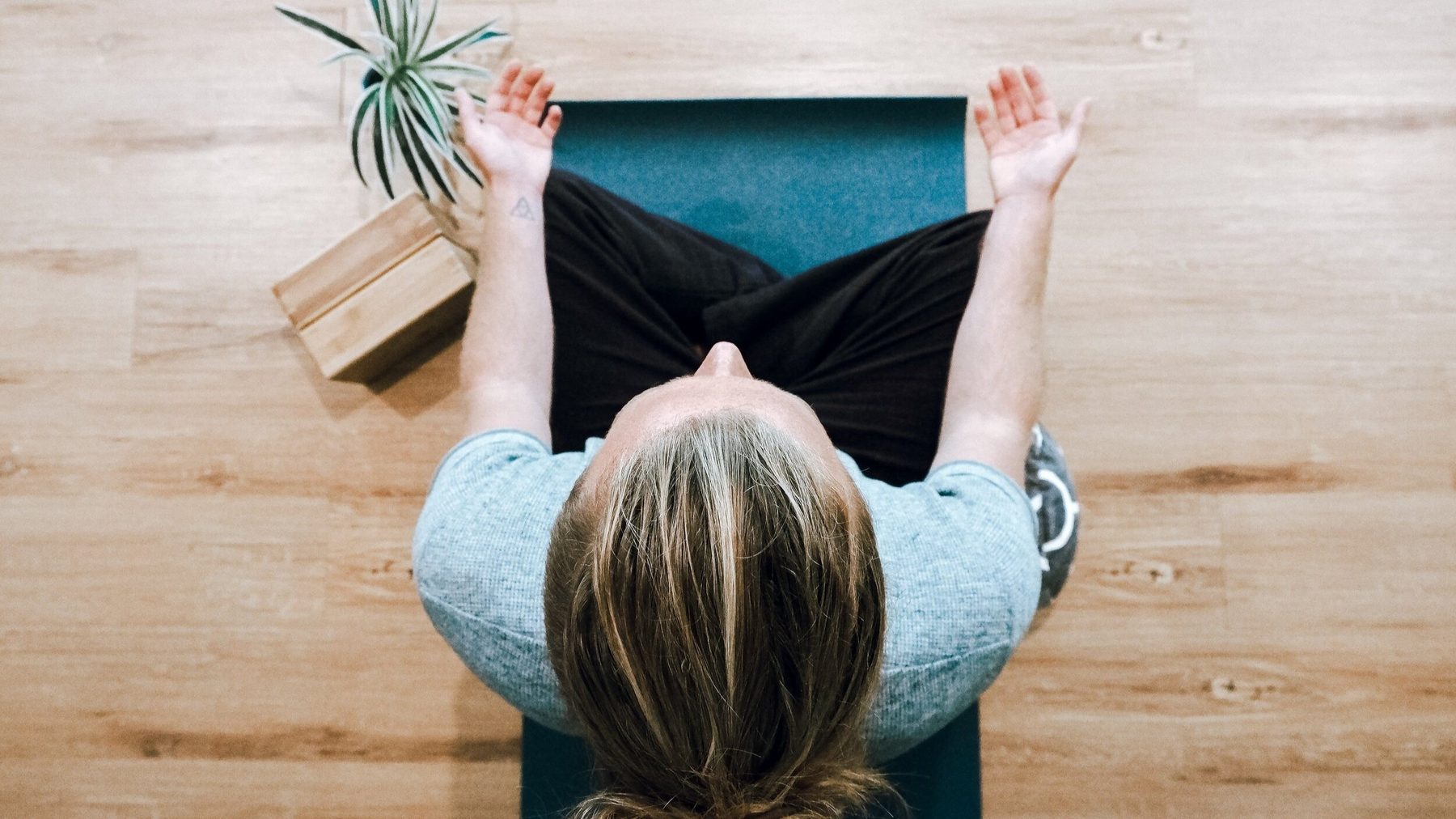 Woman seated on a yoga mat during a chakra balancing meditation