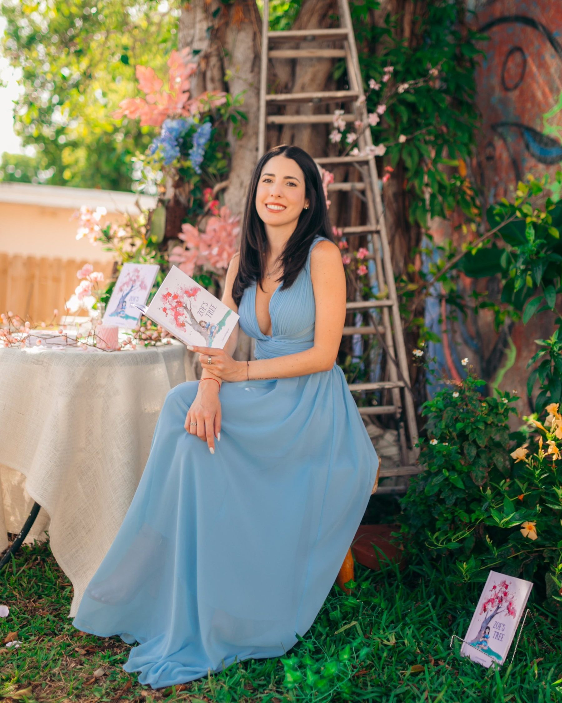 Caro Rodriguez holding a copy of her book Zoe's Tree